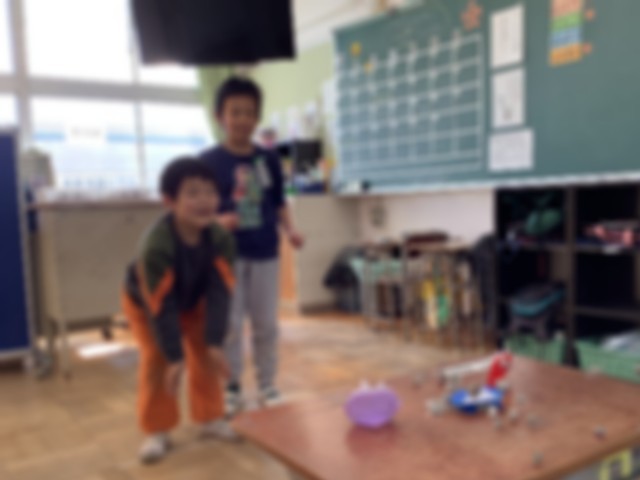 豆を投げて的を倒す児童